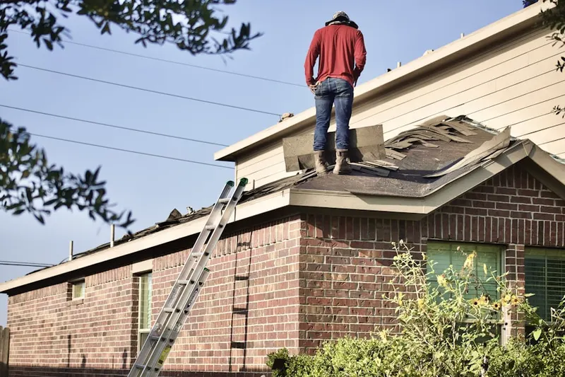 Professional roofer working on a residential roof in Stonefield